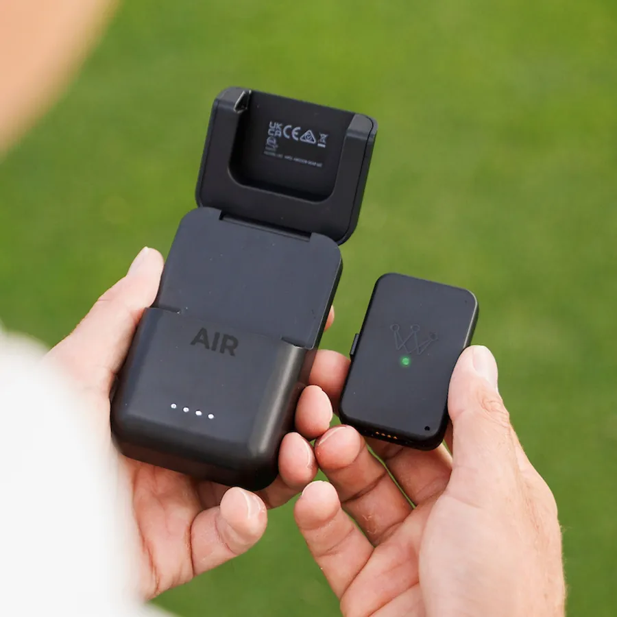 Arccos Air wearable beside its open wireless charging case